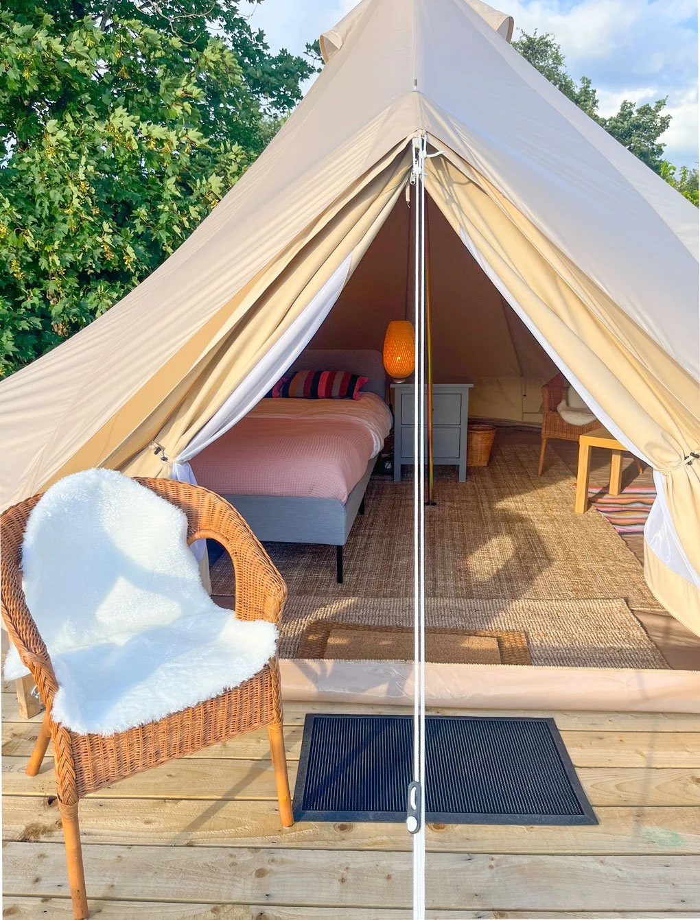A bell tent open onto its private raised timber deck at Greystones Glamping